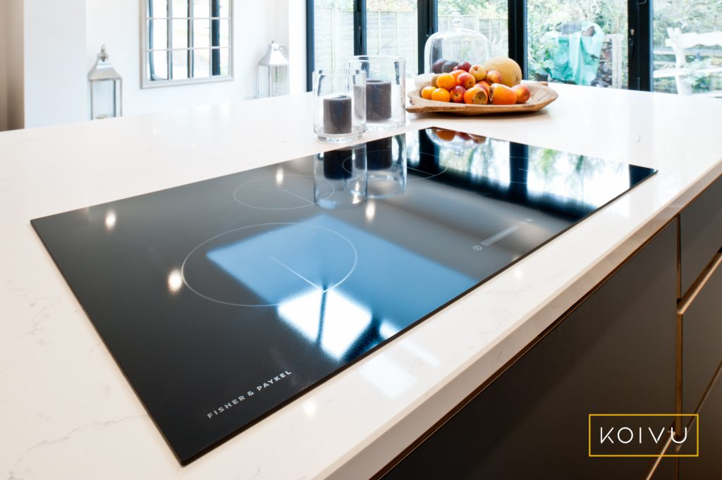 A large induction hob sunk into a white worktop. 