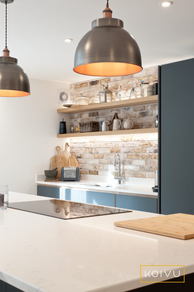 A dark grey plywood kitchen fitted in Tonbridge by Koivu. Design includes exposed stonework, island and modern pendant lights. By Koivu,