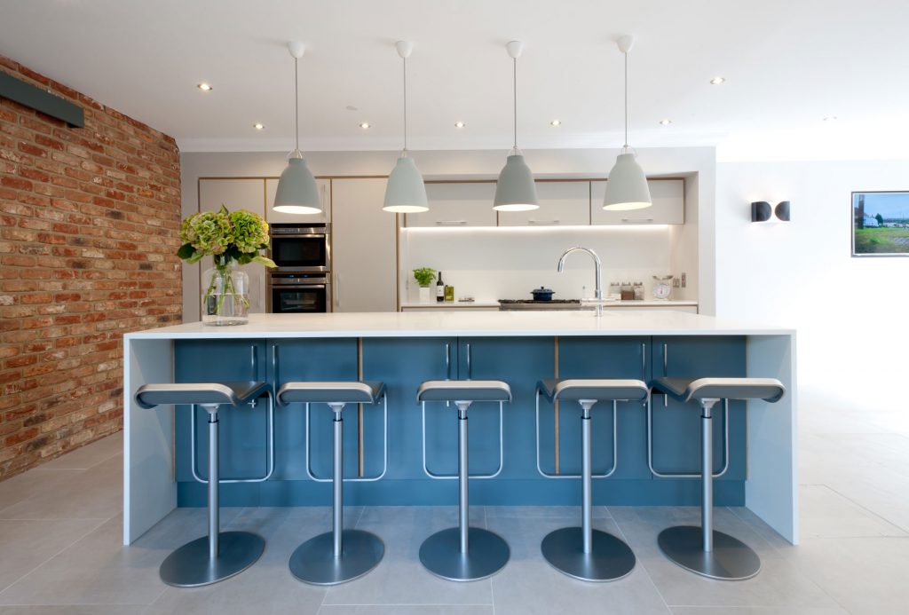 A blue plywood kitchen with island / breakfast bar and exposed brickwork for interest. We'll help you with refining your new kitchen design to create something truly beautiful.