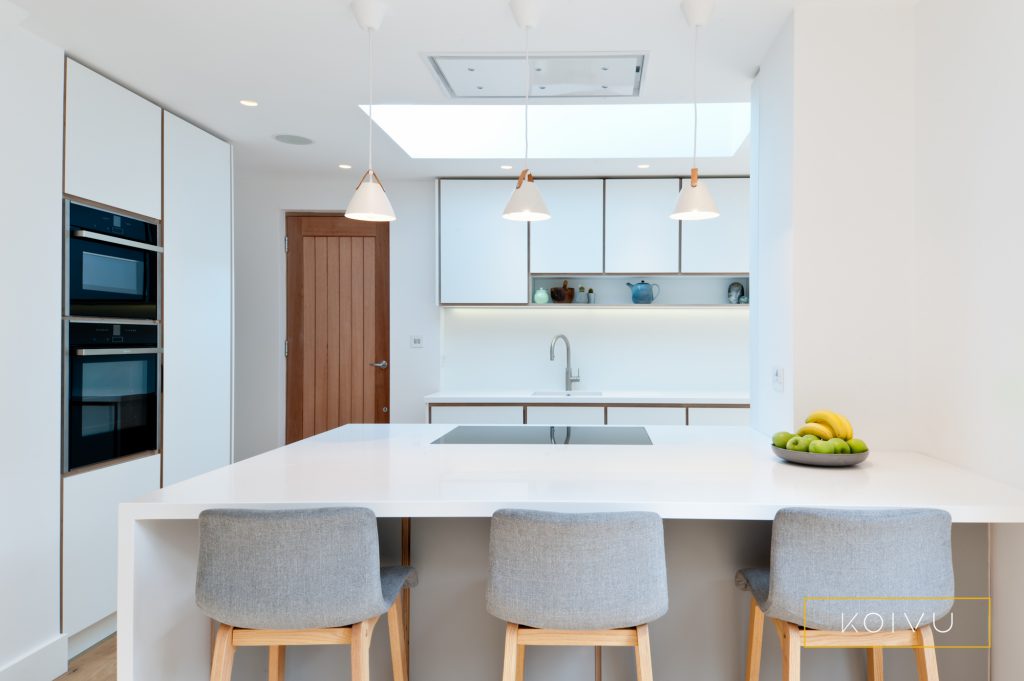 A white and grey plywood kitchen designed for a couple in Crystal Palace.