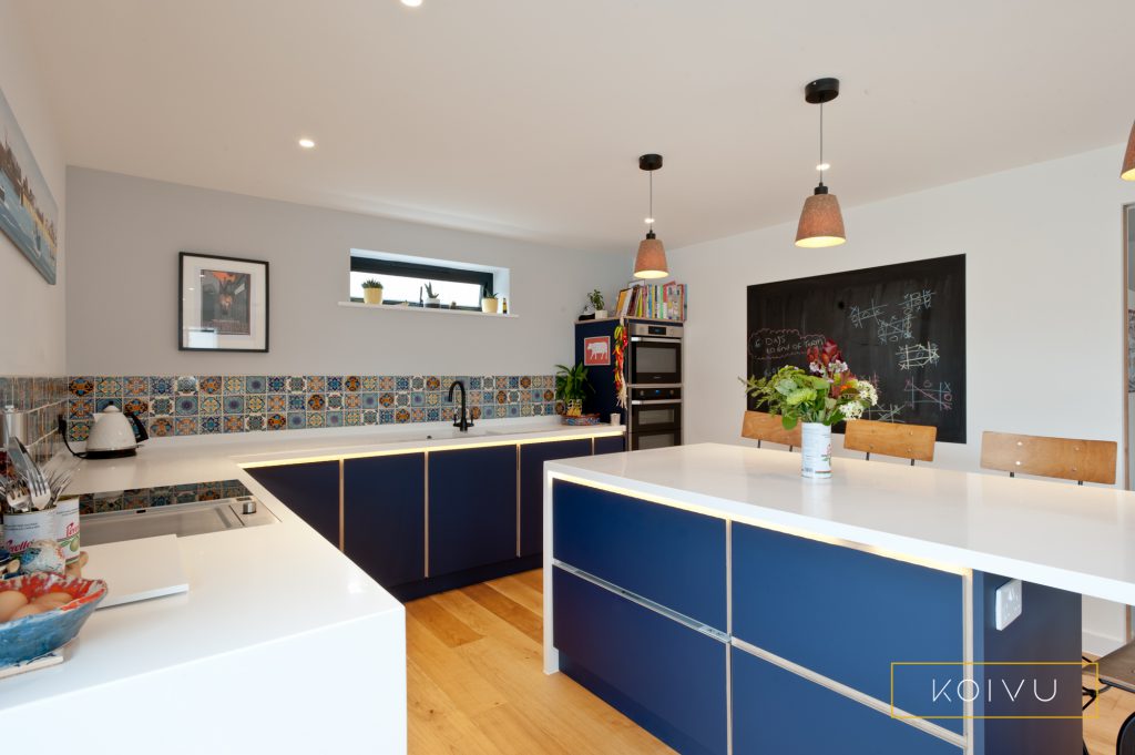 Low level kitchen with one mid-level oven housing and large island. By Koivu Kitchens.