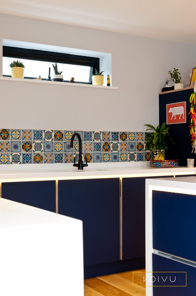 Dark blue kitchen units with white countertops in this striking kitchen in Whitstable. By Koivu.