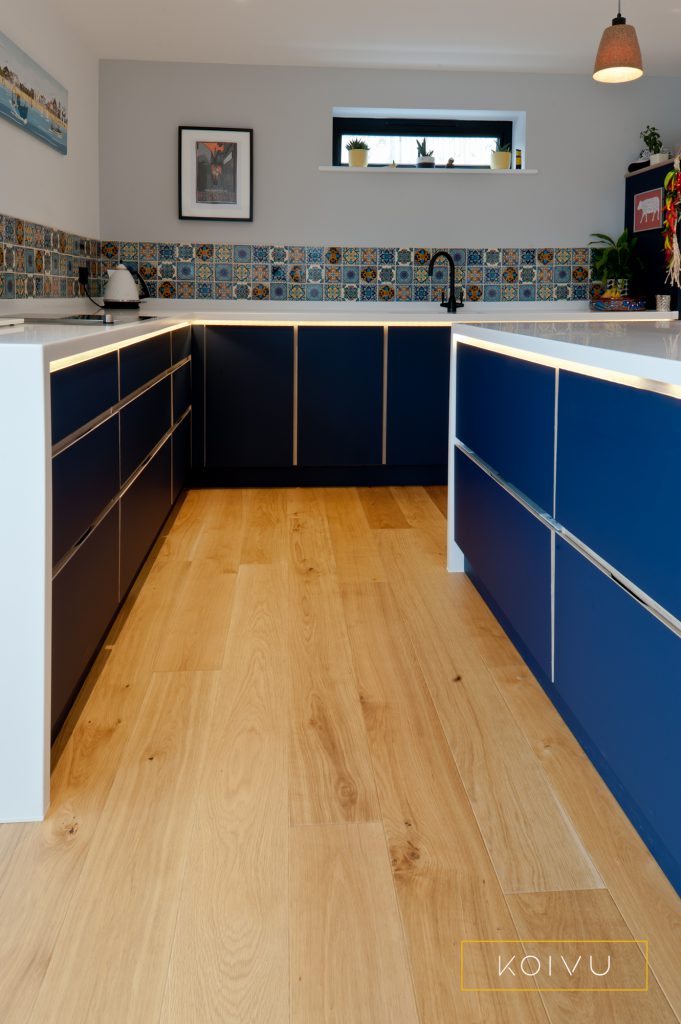 Dark blue kitchen with low level units and deep fridge drawers. By Koivu.