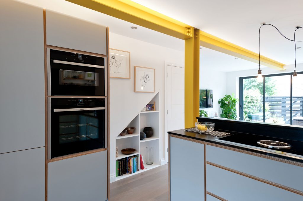 Bespoke birch plywood kitchen from Koivu built to accommodate this yellow steel beam supporting a large extension. By Koivu.