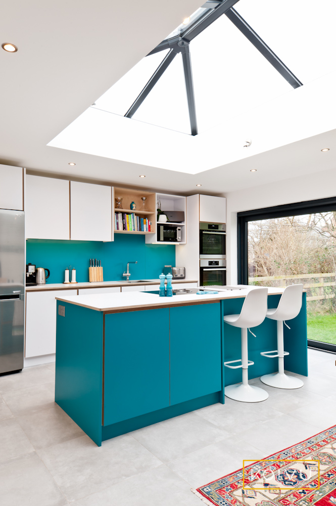 A small turquoise kitchen with an island. Designed by Koivu.