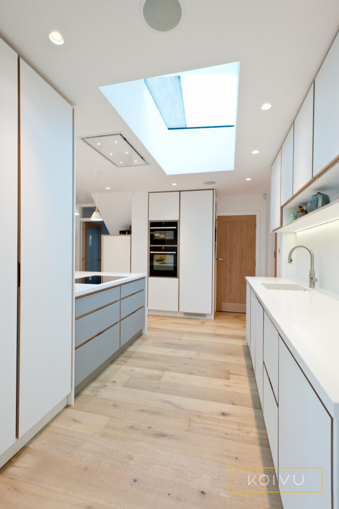 White plywood kitchen view with oak floor and roof light