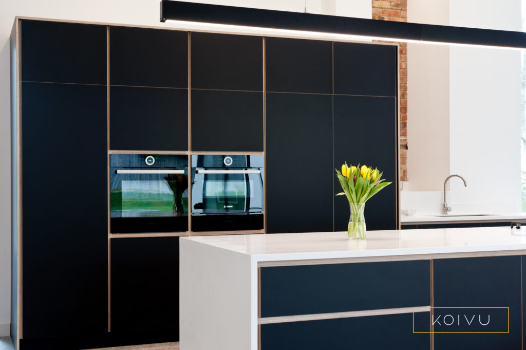 Black birch plywood kitchen that looks like you want to run your hand across it and feel how tactile the materials are. 