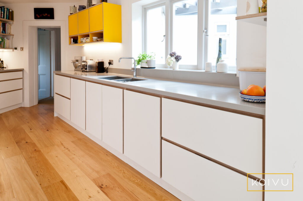 A bespoke design in an unusually shaped space. Yellow and white kitchen from Koivu. 