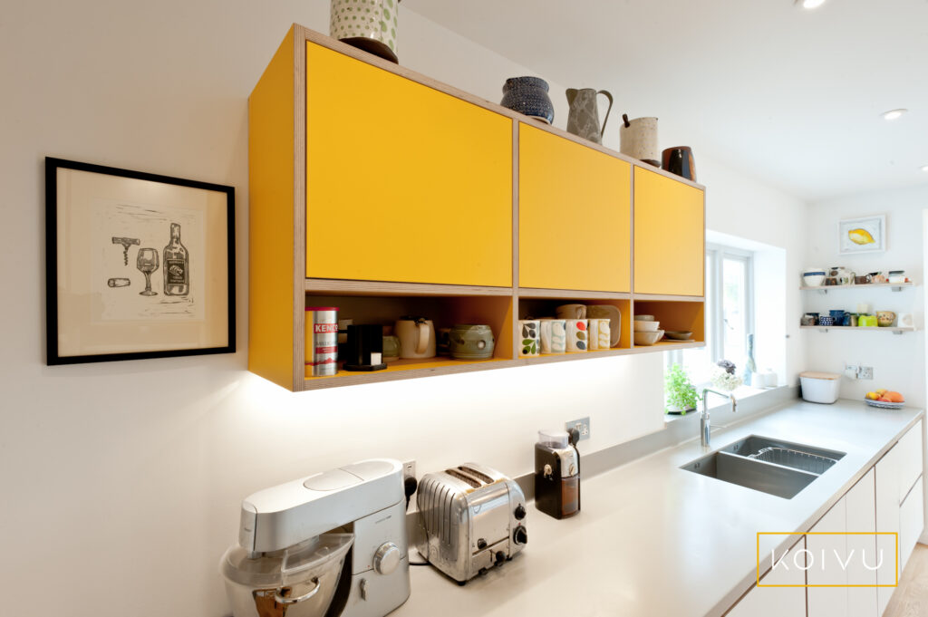 Narrow white and yellow plywood kitchen in Tunbridge Wells. By Koivu.