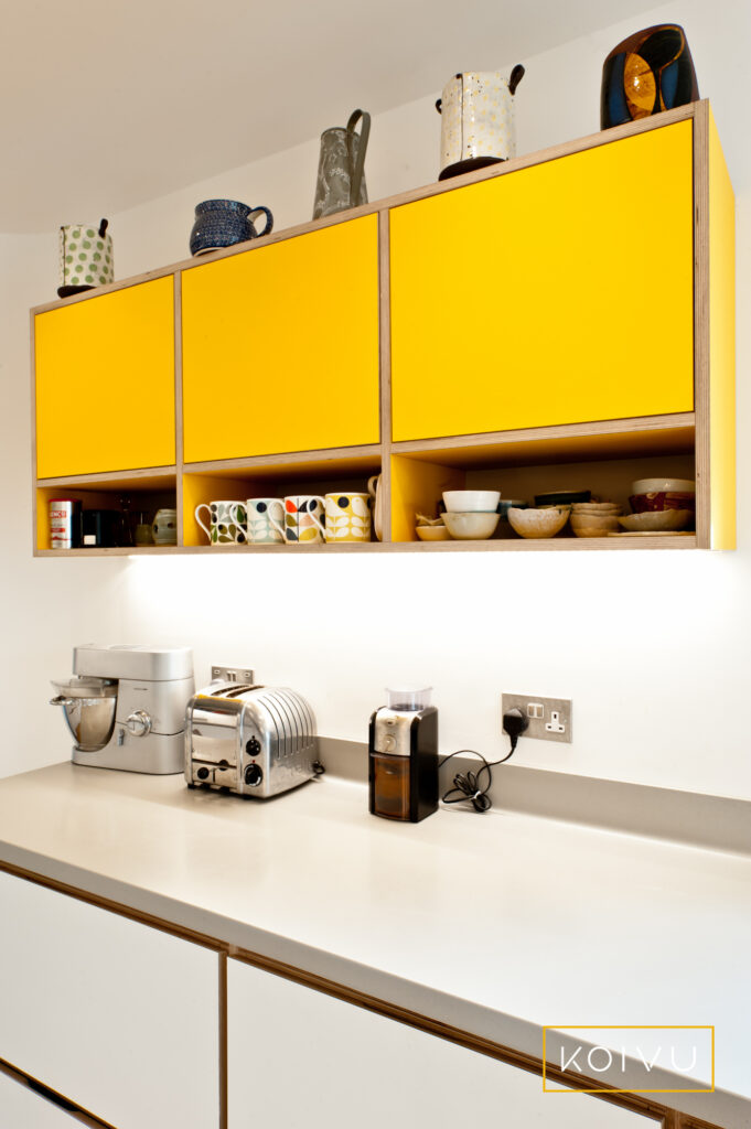 Bright yellow box cabinets with integrated open shelves below. Beautiful birch plywood from Koivu.