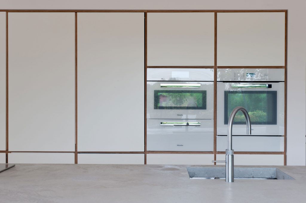 Hidden butler's cupboard in a white plywood kitchen designed by Koivu