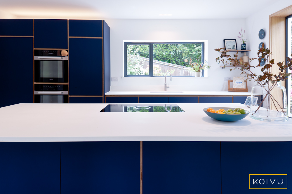 An example of a popular Koivu kitchen design in dark blue plywood with a white work surface.