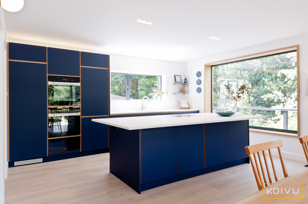 Dark blue kitchen cabinets made from sustainable birch plywood.