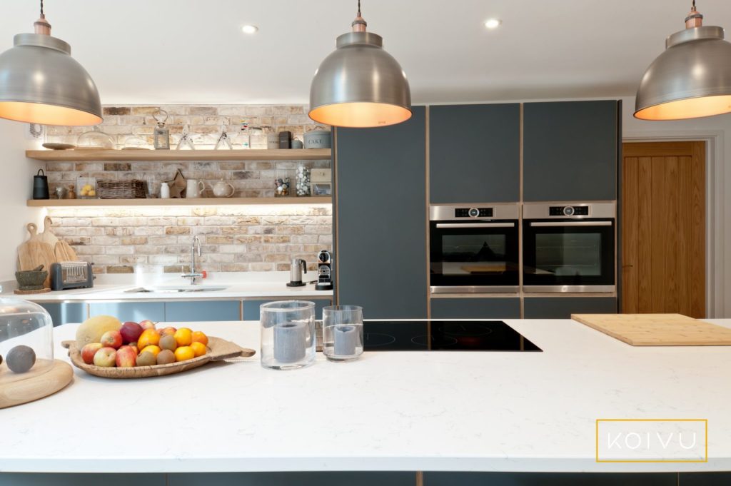 Pendant lights over a breakfast bar with spotlights behind. Demonstrating the idea of zone lighting for a more energy-efficient approach. 