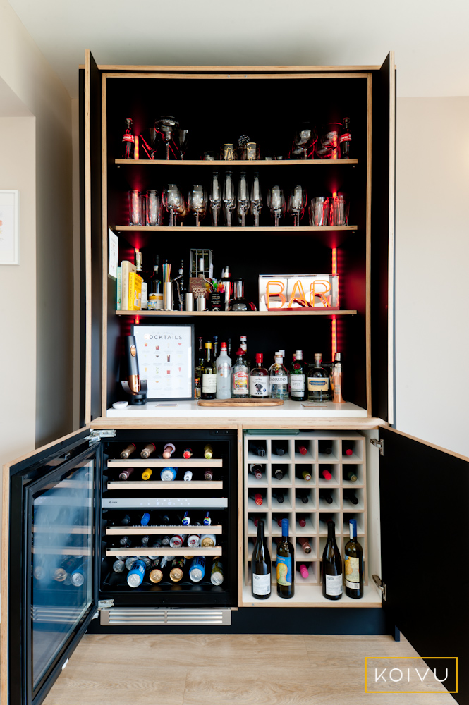 Bespoke black plywood drinks cabinet designed and made by Koivu. This features pocket doors to keep things tidy as well as a wine rack, a wine cooler and plenty of shelves for spirits.